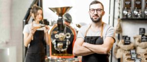 coffee shop owner with a coffe machine on the background