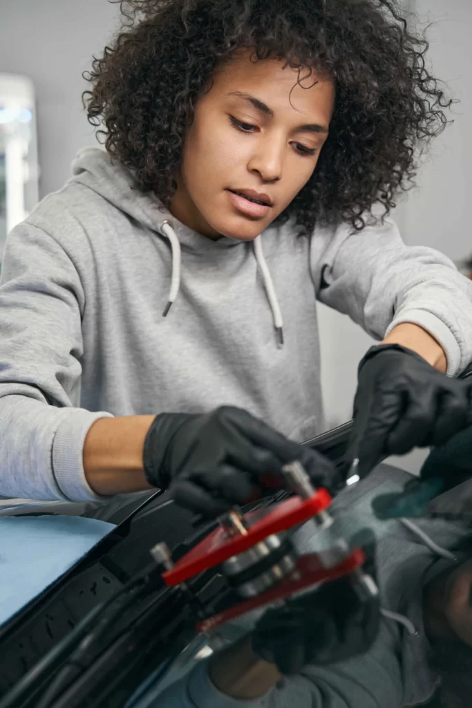 concentrated-auto-mechanic-installing-windshield